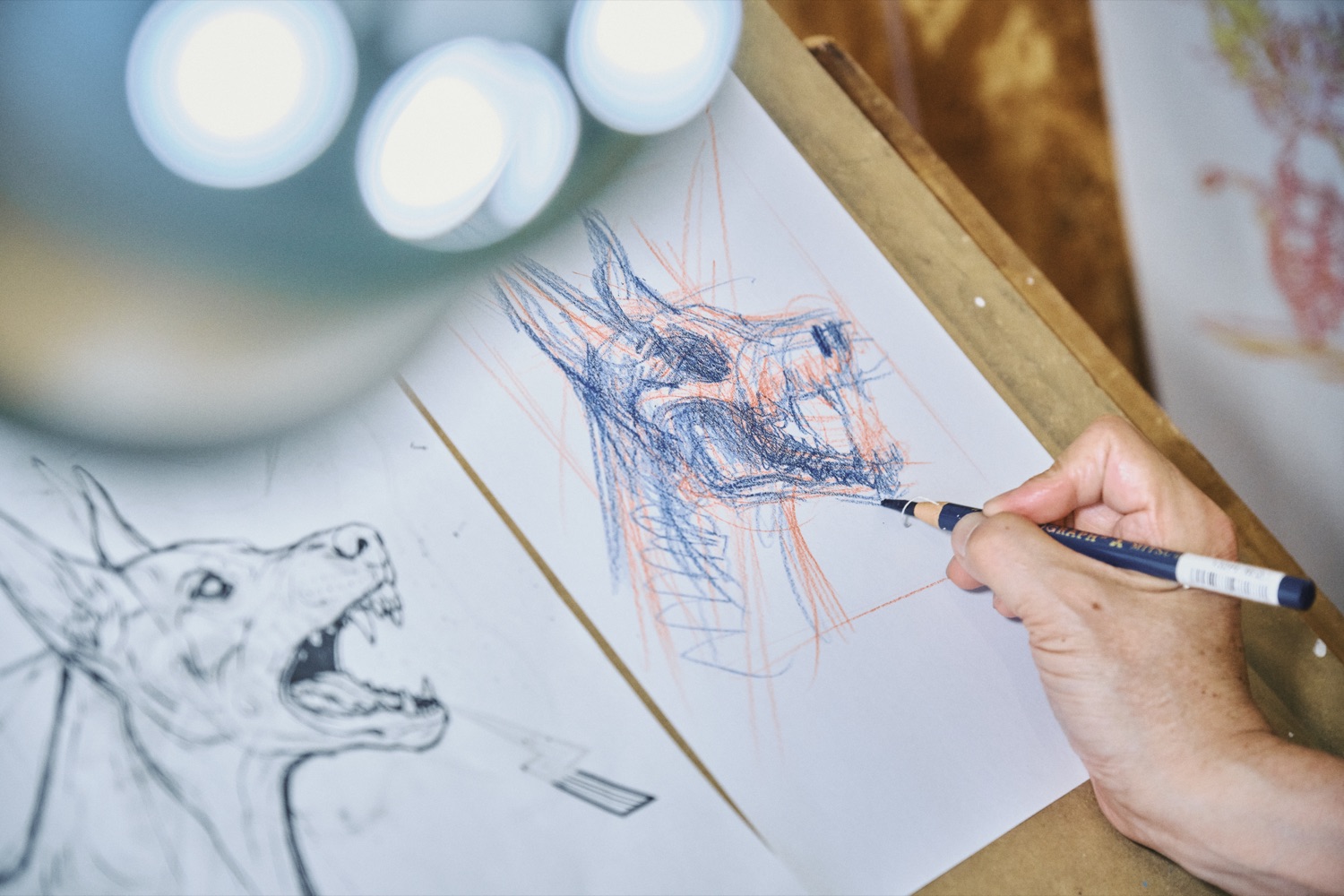 製図台でスケッチを描くカズ・オオモリの手元